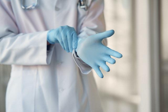 doctor putting on surgical gloves