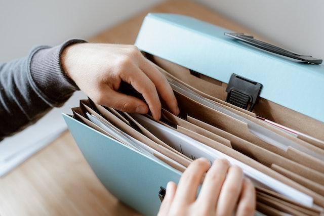 person going through files in an accordion folder