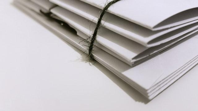 stack of papers being held together by a string