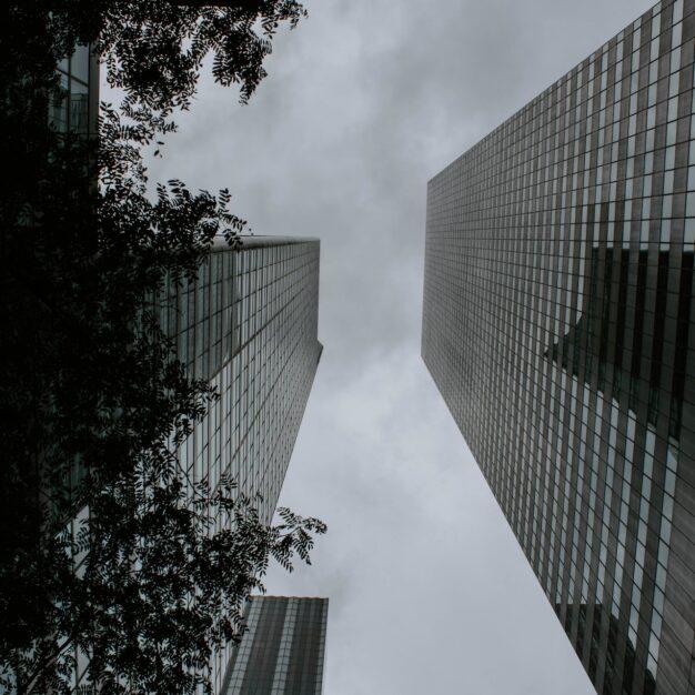 view from the base of two tall city buildings on either side of the photo