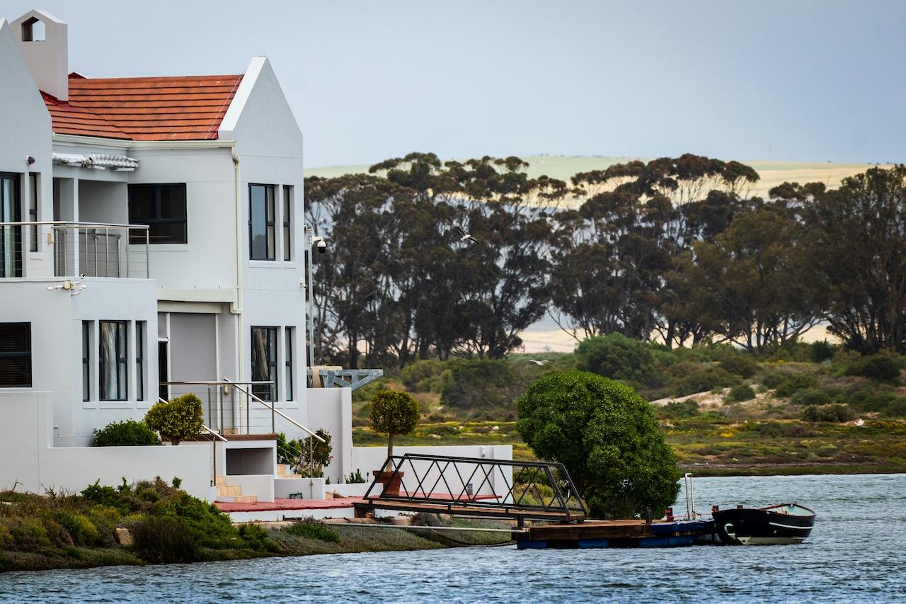 a view of a waterfront home with a dock leading to a small boat