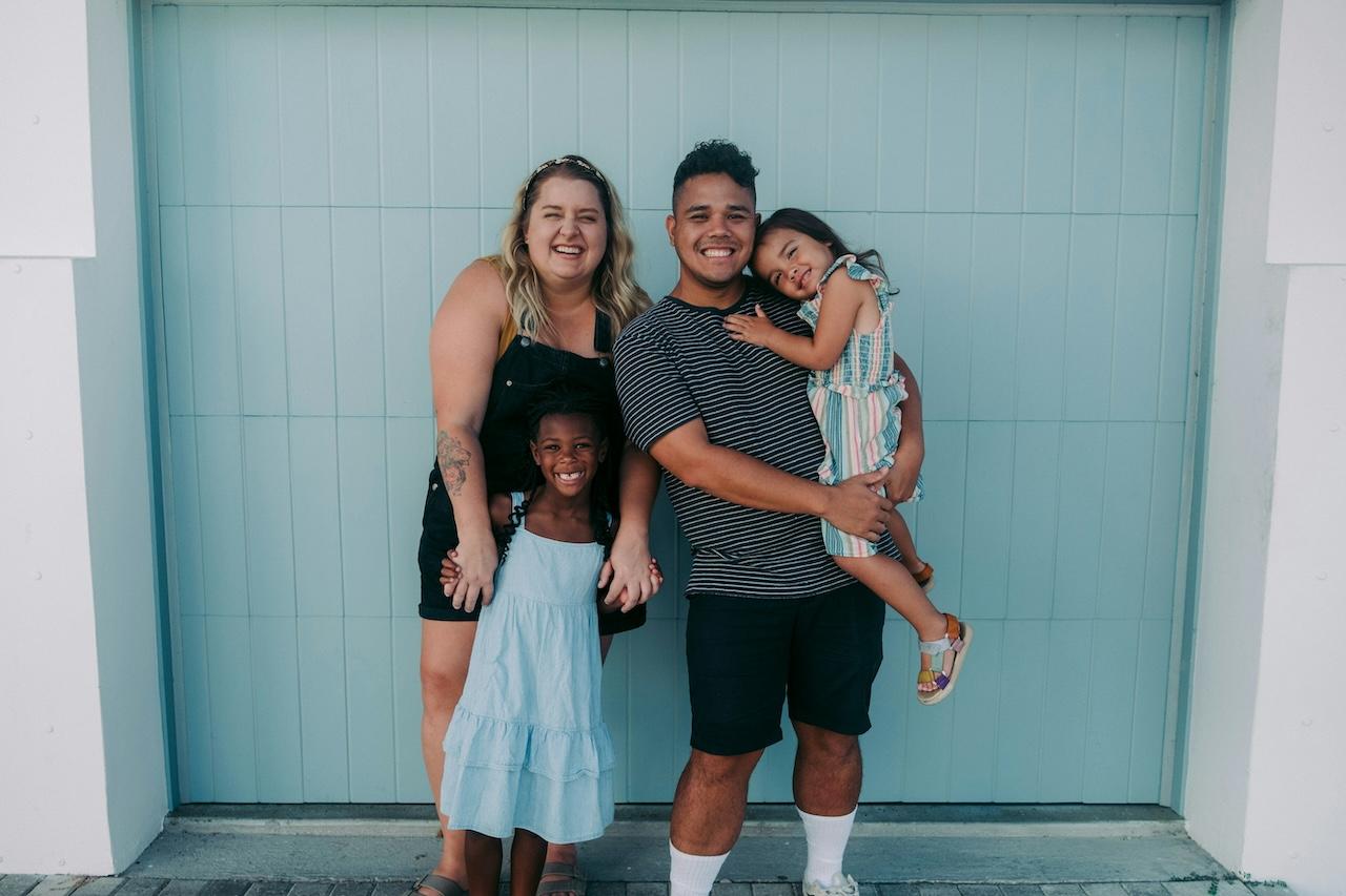 a man, woman, and two children posing for the camera