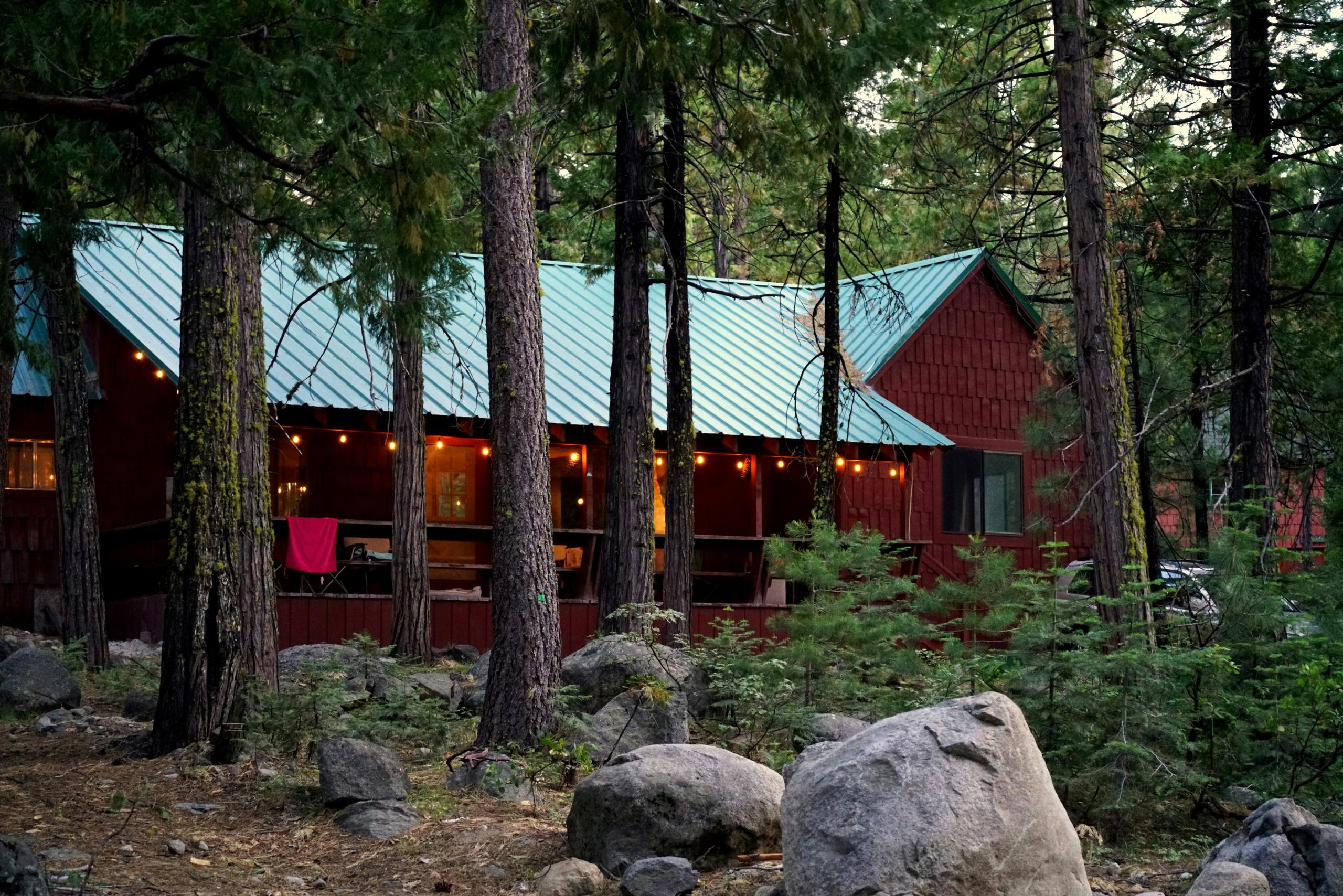 a red house surrounded by a forest